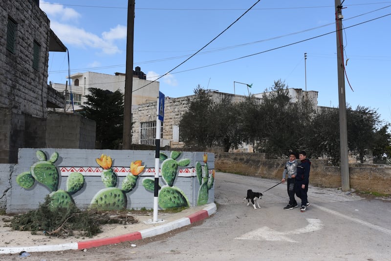 Children beside a mural in Beitin, West Bank. 