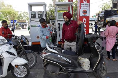 An attendant fills a scooter with petrol in Amritsar. The government increased taxes on petroleum product exports on July 1. AFP
