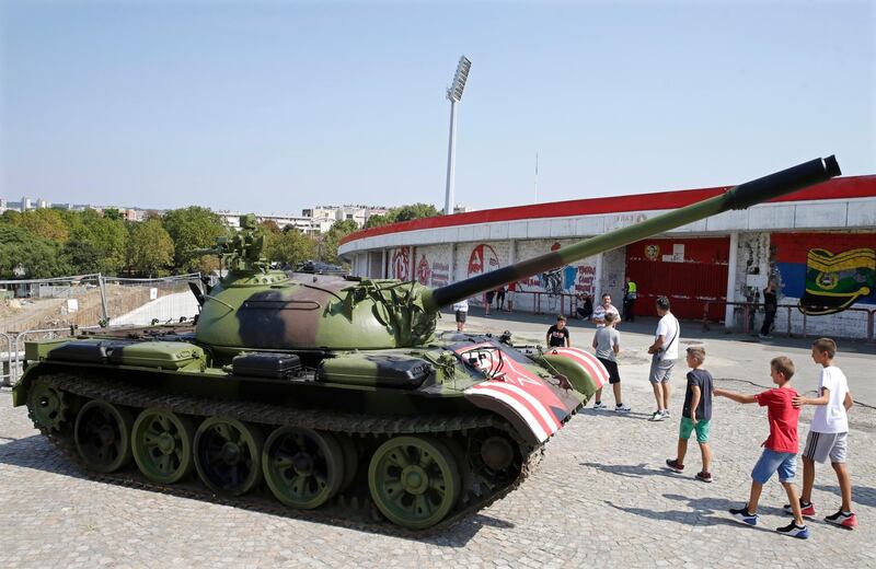 Boys walk past a former Yugoslav army T-55 battle tank in front of the northern stand of the Rajko Mitic stadium in Belgrade. EPA