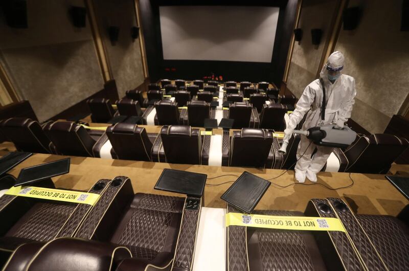 An employee sanitises a cinema in Mumbai, India. India is second in the world in total reported coronavirus cases behind the US, but daily infections have been on the decline since mid-September. AP Photo