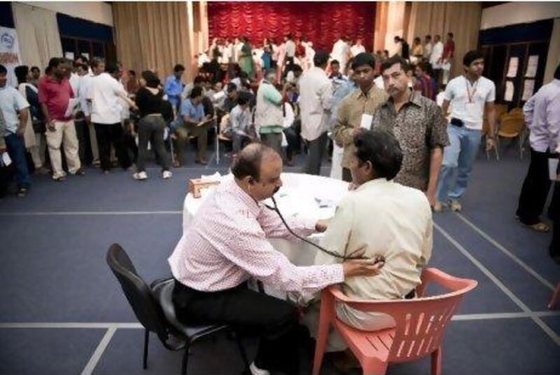 Doctors attending to labourers without medical insurance at a free medical camp organised by the Indian Ladies Association, Dubai at the Indian Consulate Dubai on Friday, February 11, 2011.