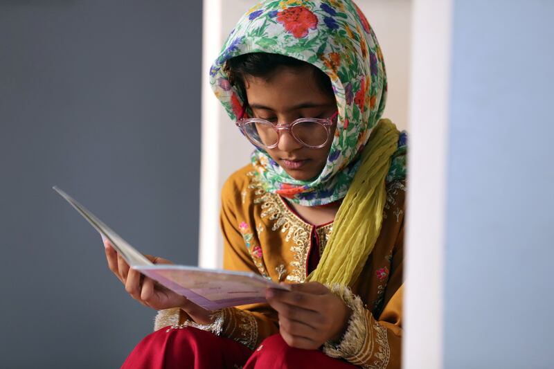 Jannat Khan, 8, reads her book on Arabic letters.