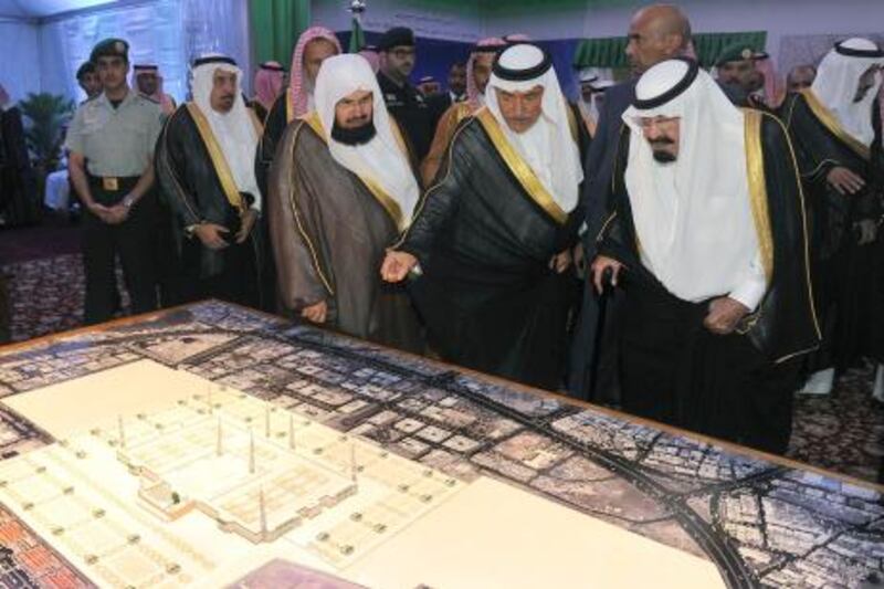 Saudi King Abdullah (R) looks at a model of Prophet Mohammed's mosque, one of Islam's three oldest mosques in the world, during laying the foundation stone ceremony for its development and expansion of the,  in the holy city of Medina on September 25, 2012. AFP PHOTO/AMER HILABI
 *** Local Caption ***  532194-01-08.jpg