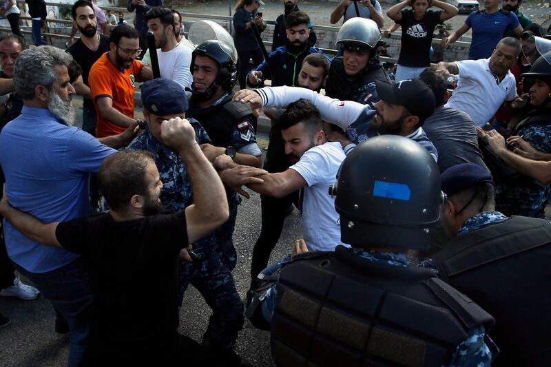 Hezbollah supporters, right, clash with anti-government protesters, left, in Beirut. AP