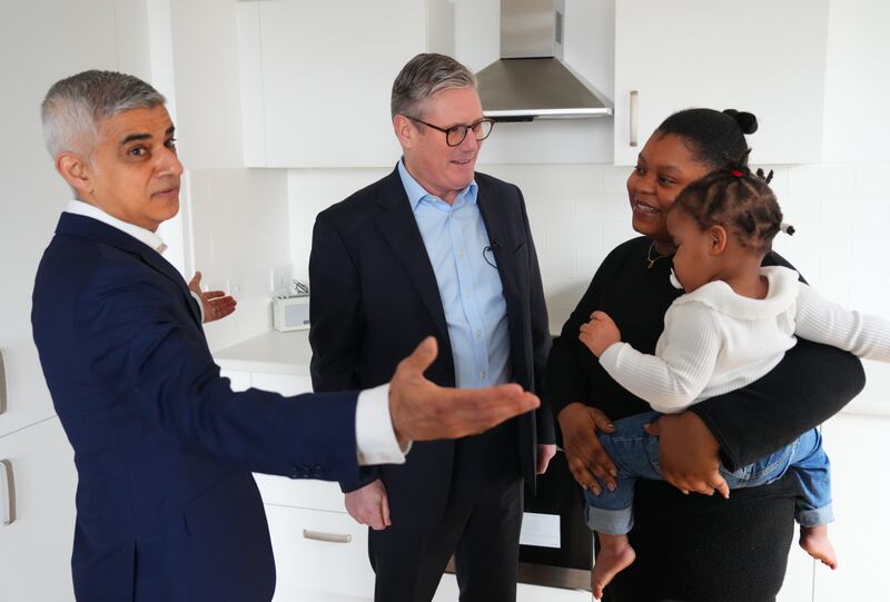 Labour leader Keir Starmer and Mr Khan speak to Shaniqua as she holds her daughter Rafaela, 1, during a housing visit in London. Getty Images
