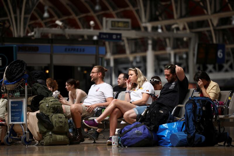 Travellers wait for a train at Paddington station in London. Reuters