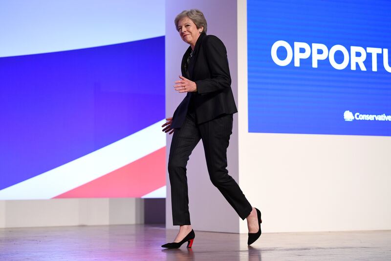 Ms May throws a few dance moves as she walks on to the stage to deliver her leader's speech during the 2018 Conservative Party Conference in Birmingham