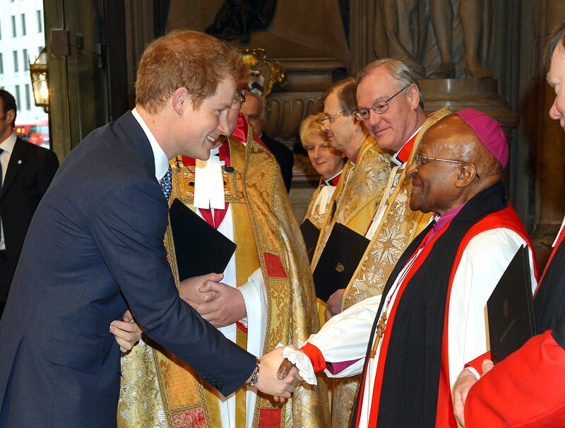 Britain's Prince Harry, now known as the Duke of Sussex, shakes hands with Tutu as he arrives at Westminster Abbey in London for a memorial service for the former South African president Nelson Mandela. PA