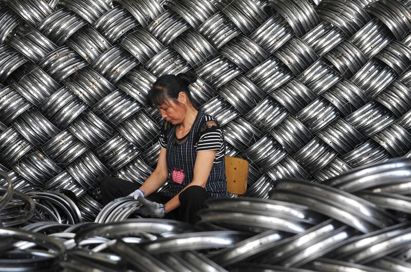 TOPSHOT - A worker checks wheel hubs of baby carriages that will be exported at a factory in Hangzhou in China's eastern Zhejiang province on June 4, 2018. China warned the US that any deals reached during ongoing trade talks would be void if Washington went ahead with imposing tariffs on Chinese goods, as the latest round of negotiations ended on June 3 in Beijing. - China OUT
 / AFP / -
