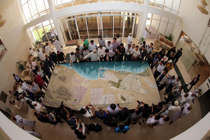 A picture taken with a fish-eye lens shows Chinese investors listening to an explanation as they check the model of the dry dock which is to be built following an economic agreement, on May 24, 2016 in the Omani port city of Duqm.
Chinese investors signed a deal with Oman's government to establish an industrial city, including an oil refinery, in the port town of Duqm, both sides said in a joint statement. The agreement signed during the ceremony in Muscat would open way for investments worth $10.7 billion by 2022 to finance industrial projects in Duqm, on the Arabian Sea, which the Omani government is developing in a bid to diversify revenues beyond oil. / AFP PHOTO / MOHAMMED MAHJOUB