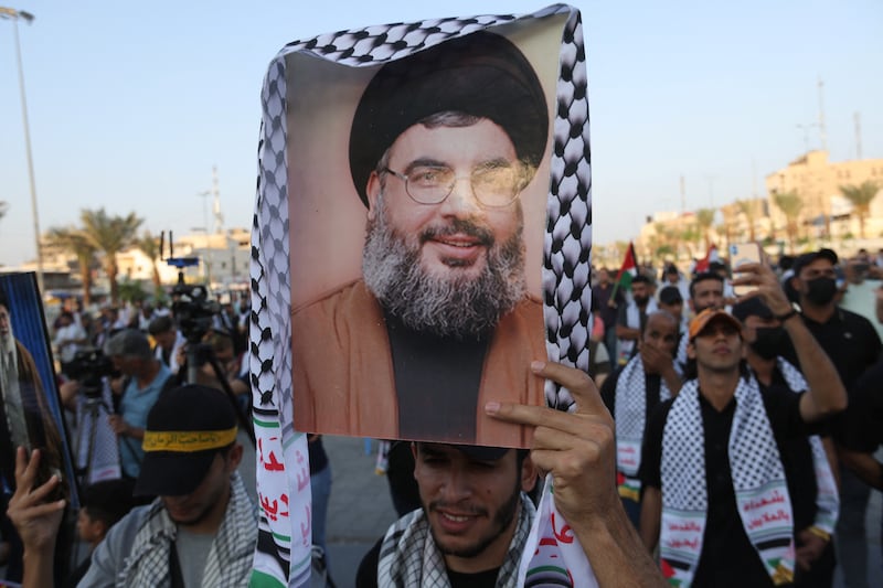 Supporters of Iraqi Shiite armed groups gather in Baghdad's Tahrir Square to watch the speech by Mr Nasrallah. Reuters
