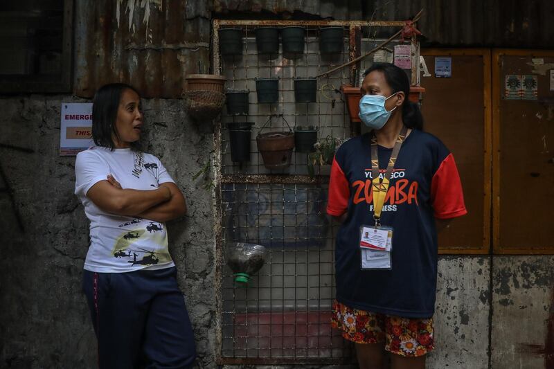 Health workers Vannessa Morales (L) and Richell Arsenio (R) have a chat before doing their rounds in Manila, Philippines. They are part of a group of four volunteer health workers who were nicknamed 'Astronauts' by residents of Village 775, Zone 84 in Manila as they resemble such when donning their protective equipment. The healthcare volunteers conduct home visits twice a day to people infected or suspected to be infected with the novel SARS-CoV-2 coronavirus that causes the COVID-19 disease in one of the densely populated villages in Manila.  EPA