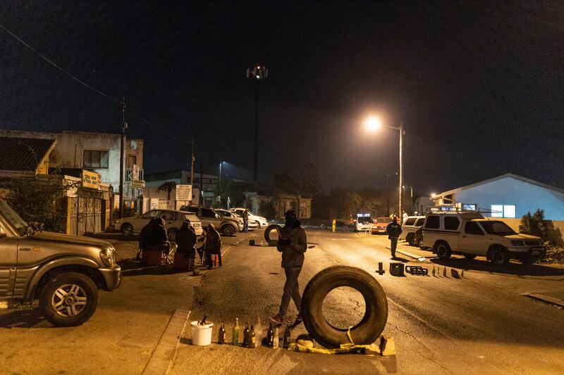 Community members gather around a road block they set up in Phoenix Township, North Durban, on July 15, 2021.