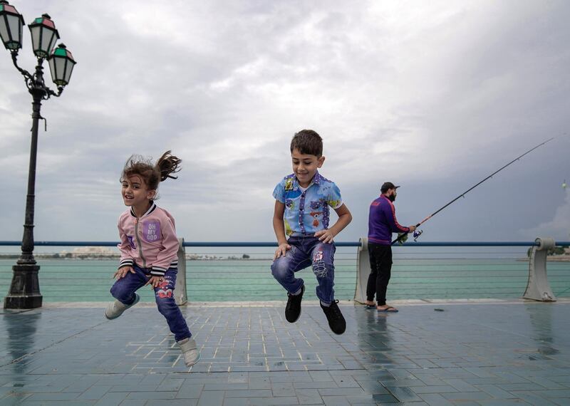Abu Dhabi, United Arab Emirates, November 20, 2019.  
 UAE weather: rainfall and storms arrive as all schools close.
--  Huda and Bakr Kaaki enjoy the cool weather and missing class today due to the rains and stormy weather on a stroll along the Corniche with their mother and grandmother.
Victor Besa / The National
Section:  NA
Reporter: