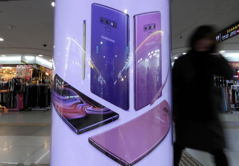 A woman walks past an advertisement poster of a Samsung Electronics Co. products at a subway station in Seoul, South Korea, Thursday, Jan. 31, 2019. Samsung Electronics Co. has posted a near-30 percent drop in operating profit for the last quarter after seeing slowing global demand for its memory chips and smartphones. It still finished the year with record highs but expects a decline in earnings this year. (AP Photo/Lee Jin-man)