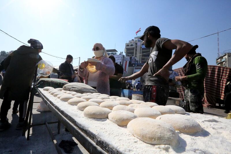 Iraqi supporters of anti-government protesters bake fresh bread as demonstrations continue in Baghdad's central Tahrir square. AFP