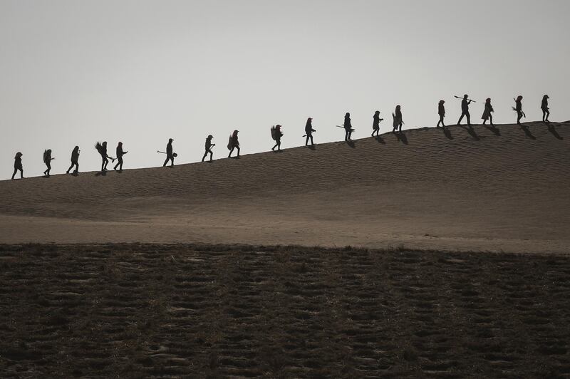 Local people walk in the desert at Mingqin county in Wuwei, Gansu Province. China. Wang HE