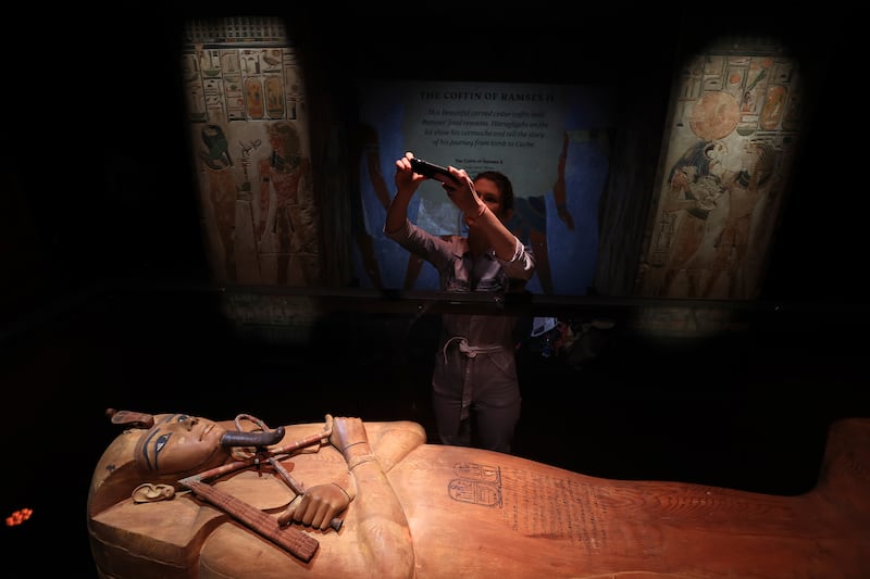 A journalist takes a photograph of the wooden coffin of Pharaoh Ramses II. AP