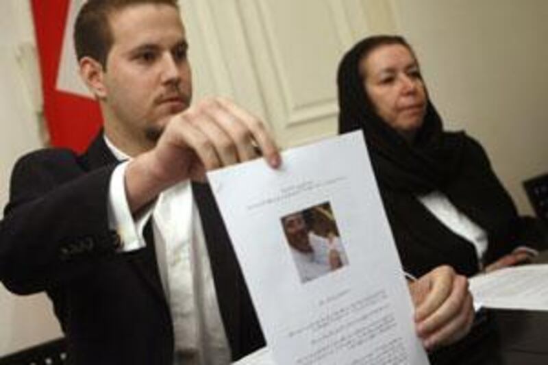 Daniel Levinson, left, displays a photo of his father, the former FBI agent Robert Levinson, holding his grandson Ryan, during a press conference with his mother Christine at the Swiss embassy in Tehran in December 2007.