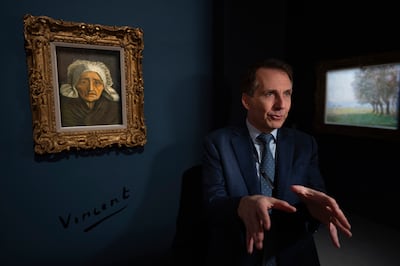 Bill Rau, president of the MS Rau gallery, next to Vincent van Gogh's painting Head of a Peasant Woman in a White Headdress. AP