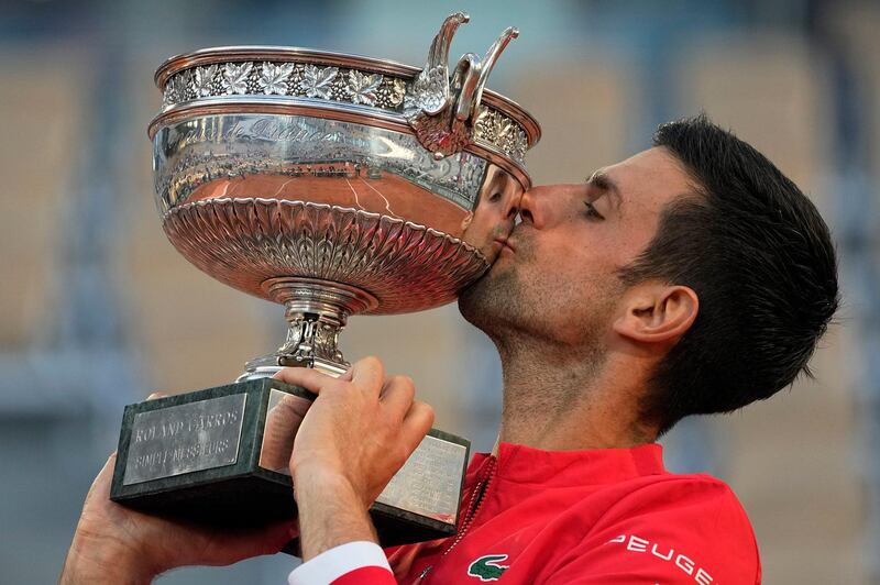 Serbia's Novak Djokovic kisses the cup after defeating Stefanos Tsitsipas of Greece in their final match of the French Open tennis tournament at the Roland Garros stadium Sunday, June 13, 2021 in Paris. Djokovic won 6-7 (6), 2-6, 6-3, 6-2, 6-4. (AP Photo/Michel Euler)
