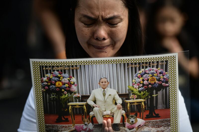 A woman cries whilst paying her respects to the late Thai King Bhumibol Adulyadej outside of the Grand Palace in Bangkok on October 15, 2016. Lillian Suwanrumpha / AFP 

