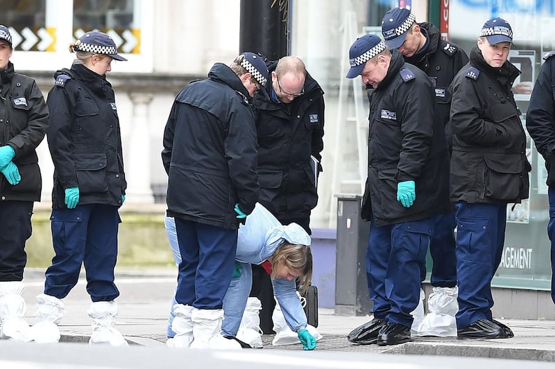 Police officers conduct a search on Streatham High Road in south London on February 3, 2020, after a man was shot dead by police on February 2, following reports he had stabbed two people. British police were searching two homes on Monday after shooting dead a convicted terrorist who knifed two people in a London street. Sudesh Amman, 20, who was wearing a fake suicide vest, was shot on a busy road in south London on Sunday after what police said was an "Islamist-related" incident. / AFP / DANIEL LEAL-OLIVAS
