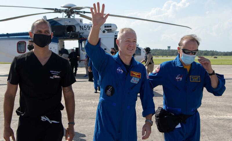 NASA astronaut Douglas Hurley waves to onlookers as he boards a plane at Naval Air Station Pensacola to return him and NASA astronaut Robert Behnken home to Houston a few hours after the duo landed in their SpaceX Crew Dragon Endeavour spacecraft. REUTERS
