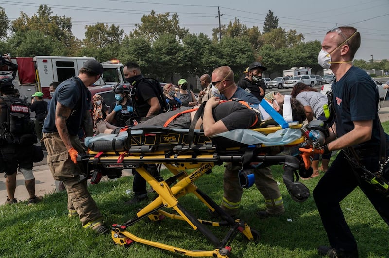 Sacramento Metro Fire first responders attend to a protester who was injured when the California Highway Patrol vehicle she was climbing on accelerated quickly and drove away at the intersection of Watt Avenue and Airbase Drive in North Highlands in Sacramento, California. AP