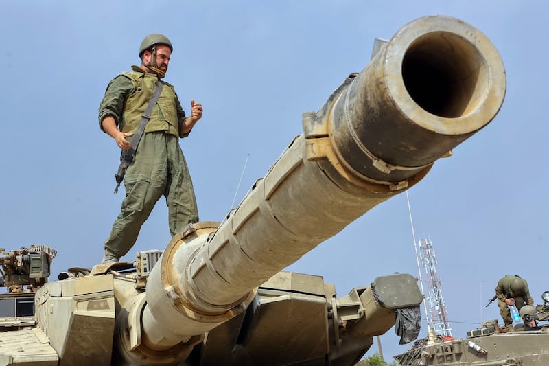 A soldier stands on the turret of a Merkava tank near the Gaza border. Military analysts have said Israel has the equipment and tactics to fight in Gaza but Hamas will prove formidable. AFP