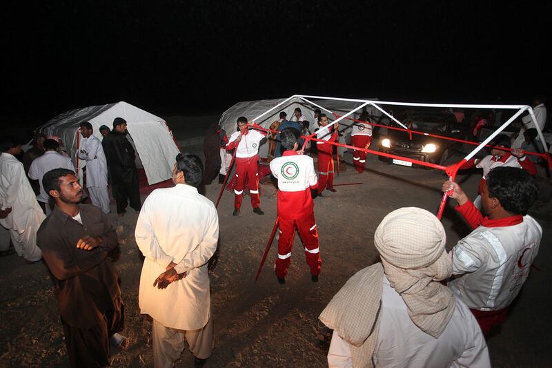 Iranian red crescent workers erect tents for victims of an earthquake in the city of Saravan, in Sistan-Beluchistan province, in south-eastern Iran on April 16, 2013.  The epicentre of the 7.8 magnitude quake lay in southeast Iran but all of the deaths so far have been reported across the border in Pakistan's remote province of Baluchistan, where hundreds of mud-built homes suffered damage. AFP PHOTO / MEHR NEWS / HAMID SADEGHI
 *** Local Caption ***  926976-01-08.jpg