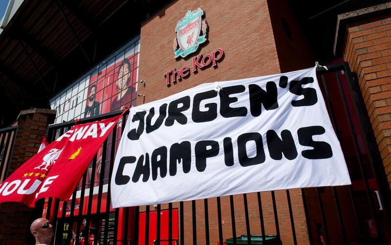 Banners and flags hung up by Liverpool ] fans flutter from a fence outside the Kop end of Anfield stadium. EPA