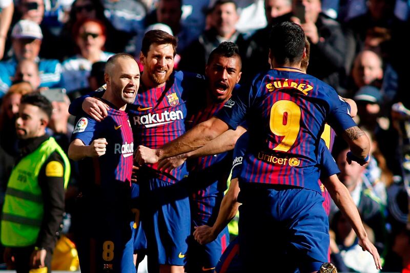 TOPSHOT - Barcelona's Argentinian forward Lionel Messi (2L) celebrates with Barcelona's Spanish midfielder Andres Iniesta, Barcelona's Brazilian midfielder Paulinho and Barcelona's Uruguayan forward Luis Suarez after scoring during the Spanish League "Clasico" football match Real Madrid CF vs FC Barcelona at the Santiago Bernabeu stadium in Madrid on December 23, 2017.  / AFP PHOTO / OSCAR DEL POZO