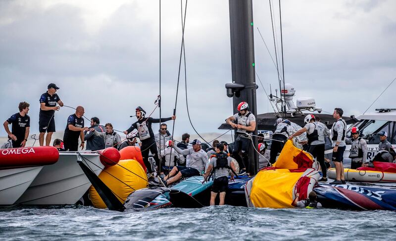 Crew from the United States' American Magic boat Patriot and Team New Zealand attempt to keep Patriot afloat after it capsized during its race against Italy's Luna Rossa on the third day of racing of the America's Cup challenger series on Auckland's Waitemate Harbour, New Zealand, Sunday, Jan. 17, 2021. (Michael Craig/NZ Herald via AP)