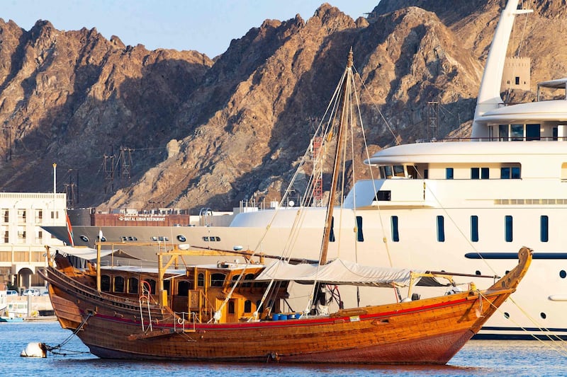 A traditional boat is moored next to a modern ship in the port of Mutrah in the Omani capital Muscat.  AFP
