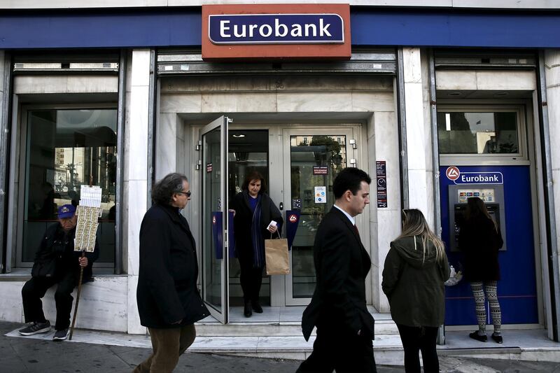 FILE PHOTO: People are seen in front of a Eurobank branch in Athens, Greece. March 19, 2015. REUTERS/Alkis Konstantinidis/File photo