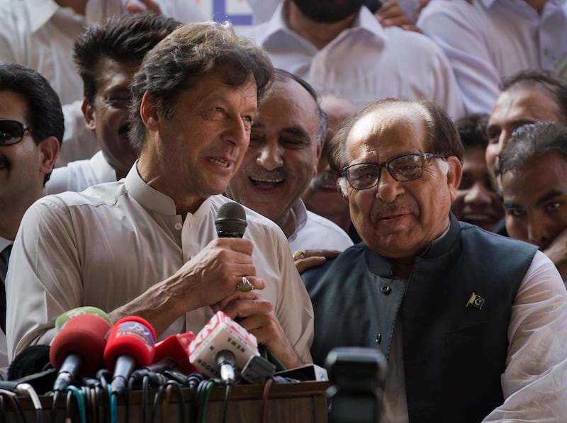 Pakistani opposition politician Imran Khan, left, chief of Pakistan Tehreek-e-Insaf party, welcomes senior politician of former prime minister of Pakistan Nawaz Sharif's party, senator Zafar Ali Shah as he joined Khan's party in Islamabad, Pakistan, Thursday, July 5, 2018. Pakistan will hold general election on July 25. (AP Photo/B.K. Bangash)