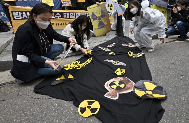 South Korean environmental activists display pictures of fishes with radioactivity warning signs during a protest against Japan's decision on releasing Fukushima wastewater, near the Japanese embassy in Seoul. AFP