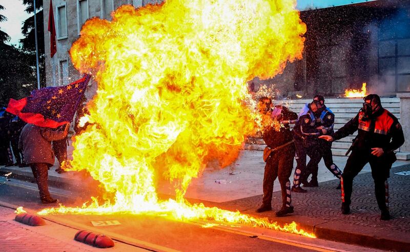 TOPSHOT - Albanian policemen try to avoid the flames from a petrol bomb during an anti-government protest called by the opposition on May 11, 2019 in Tirana. / AFP / Gent SHKULLAKU
