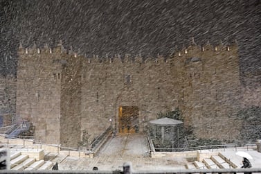 Snow falls at the Damascus Gate in Jerusalem's Old City, on February 17, 2021. AFP 