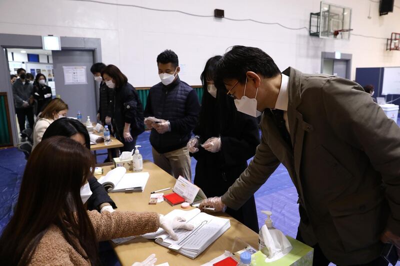 South Koreans wear masks and plastic gloves as they queue up to cast their ballots for Parliamentary election in a polling station amid the coronavirus outbreak in Seoul, South Korea. Getty Images