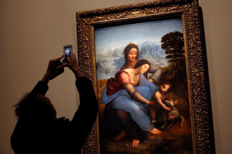 A journalist takes a snapshot of the "The Virgin and Child with Saint Anne" by Leonardo Da Vinci, at the Louvre museum, in Paris.  AP