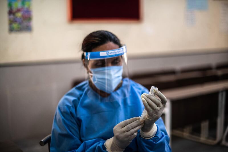 A medical worker prepares to administer a Covaxin Covid-19 shot at a vaccination centre in New Delhi. A new wave of the pandemic has totally overwhelmed India's healthcare services and has caused crematoriums to operate day and night as the number of victims continues to spiral out of control. Getty
