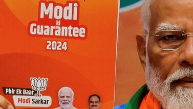 Indian PM Narendra Modi displays a copy of the ruling Bharatiya Janata Party's election manifesto for the general election, in Delhi on Sunday. Reuters