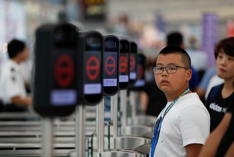 People are seen next to the temporary closed security gates as anti-extradition bill demonstrators protest at the departure hall of Hong Kong Airport, China.  Reuters