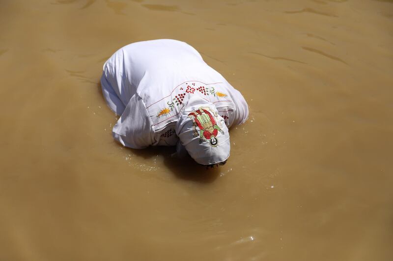 A Coptic Egyptian pilgrim submerges herself in the waters of the Jordan River after she was baptized  at the Qasr al- Yahud baptismal site near the West Bank city of Jericho. AFP