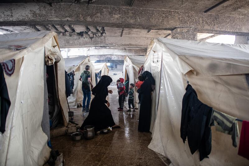 Displaced Syrians wait in front of their tents at the basement of a stadiums tribunes as it is turned into a makeshift refugee shelter in Idlib, Syria. Getty