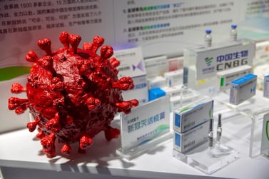 A model of a coronavirus is displayed next to boxes for Covid-19 vaccines at an exhibit by Chinese pharmaceutical firm Sinopharm at the China International Fair for Trade in Services in Beijing on September 5, 2020. AP