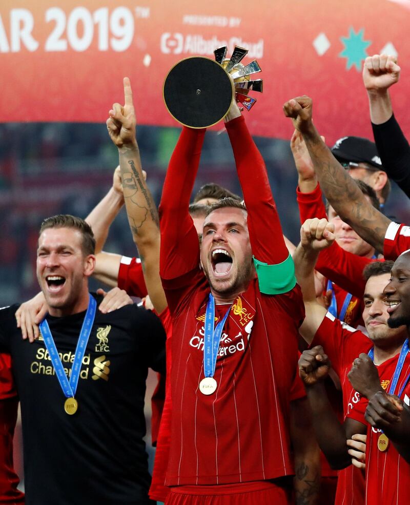 Liverpool's Jordan Henderson celebrates lifts the trophy. Reuters