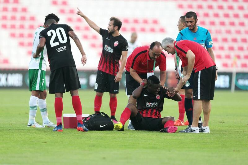 Al Ahli’s Asamoah Gyan is looked after by trainers after being tripped in the Arabian Gulf League match against Emirates on Saturday. Christopher Pike / The National